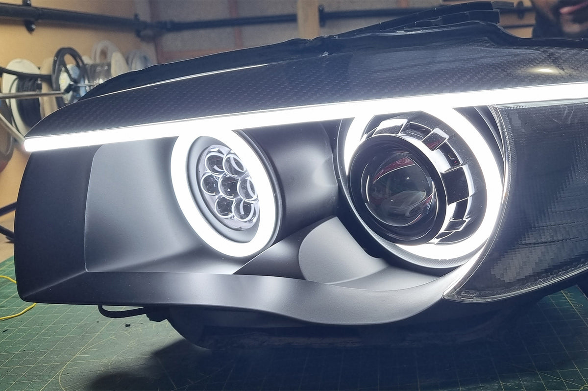 BMW 1 Series E87 & E81 E82 E88 (Pre LCI Halogen) Custom Headlights. Equipped With The Following Options: KYCS Round Angel Eyes (White) | BavGruppe Design Carbon Fibre Eyebrow With LED Strip (White) | Bi-LED Projector | LED High Beam Array