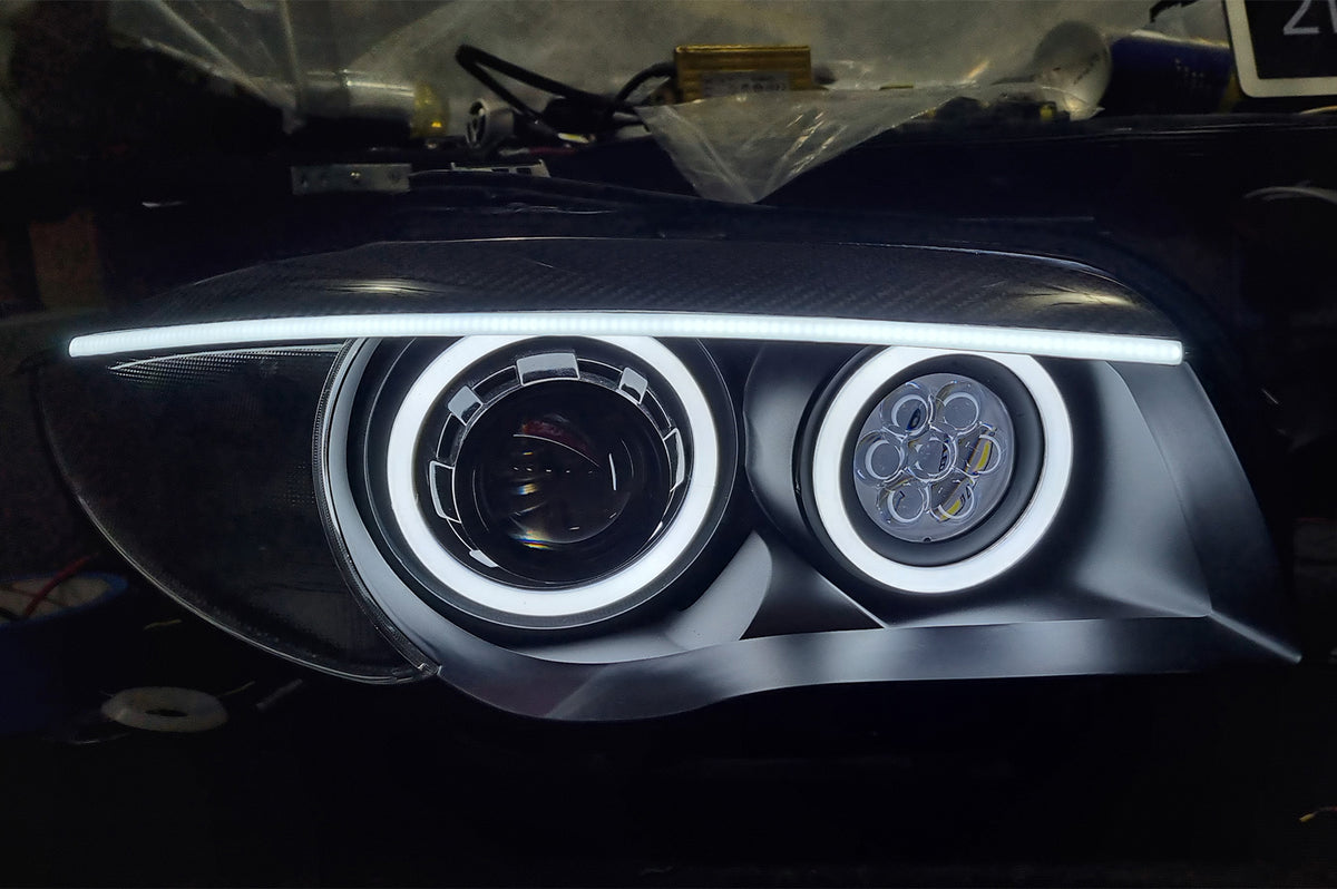 BMW 1 Series E87 & E81 E82 E88 (Pre LCI Halogen) Custom Headlights. Equipped With The Following Options: KYCS Round Angel Eyes (White) | BavGruppe Design Carbon Fibre Eyebrow With LED Strip (White) | Bi-LED Projector | LED High Beam Array