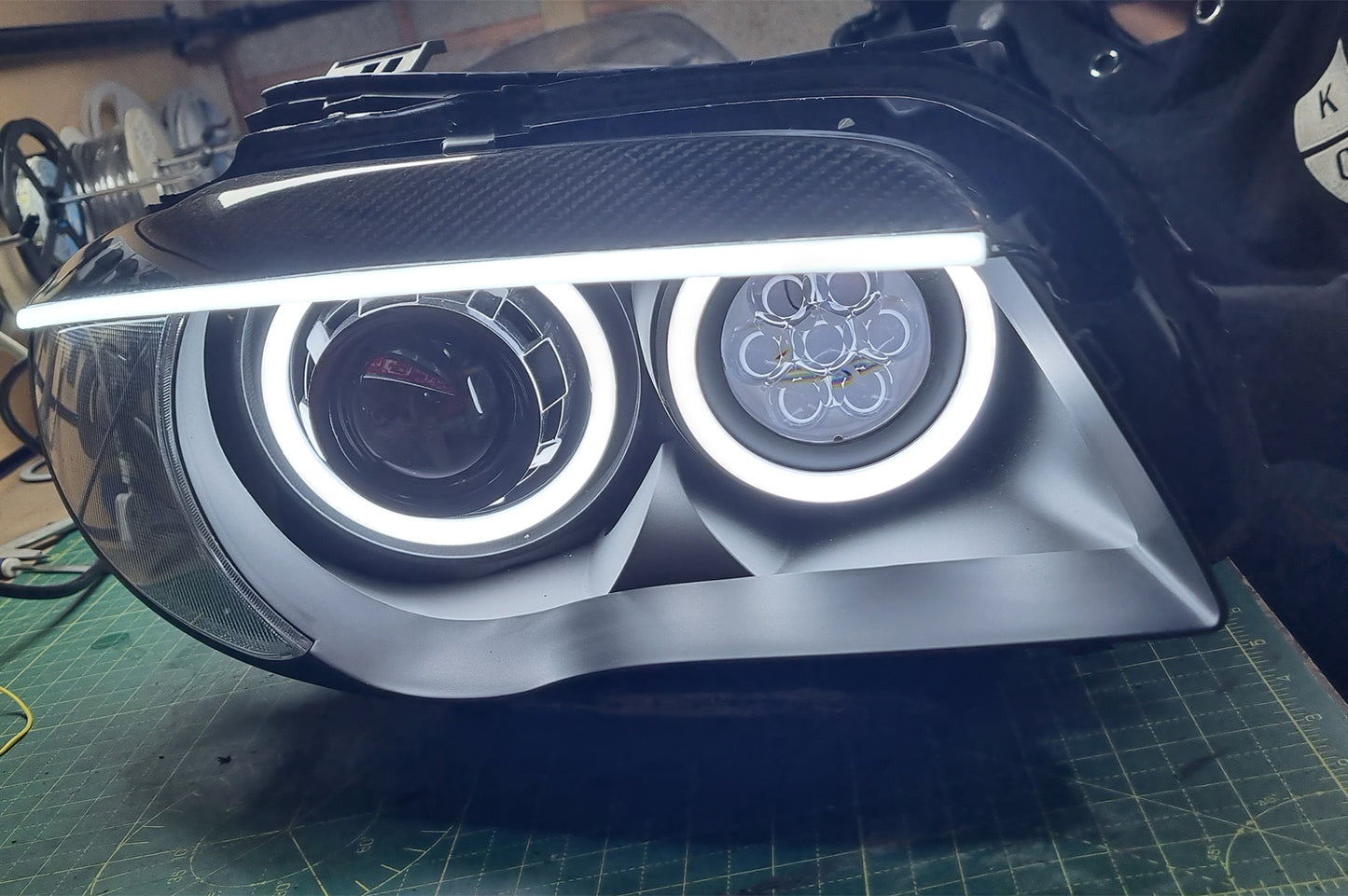 BMW 1 Series E87 & E81 E82 E88 (Pre LCI Halogen) Custom Headlights. Equipped With The Following Options: KYCS Round Angel Eyes (White) | BavGruppe Design Carbon Fibre Eyebrow With LED Strip (White) | Bi-LED Projector | LED High Beam Array