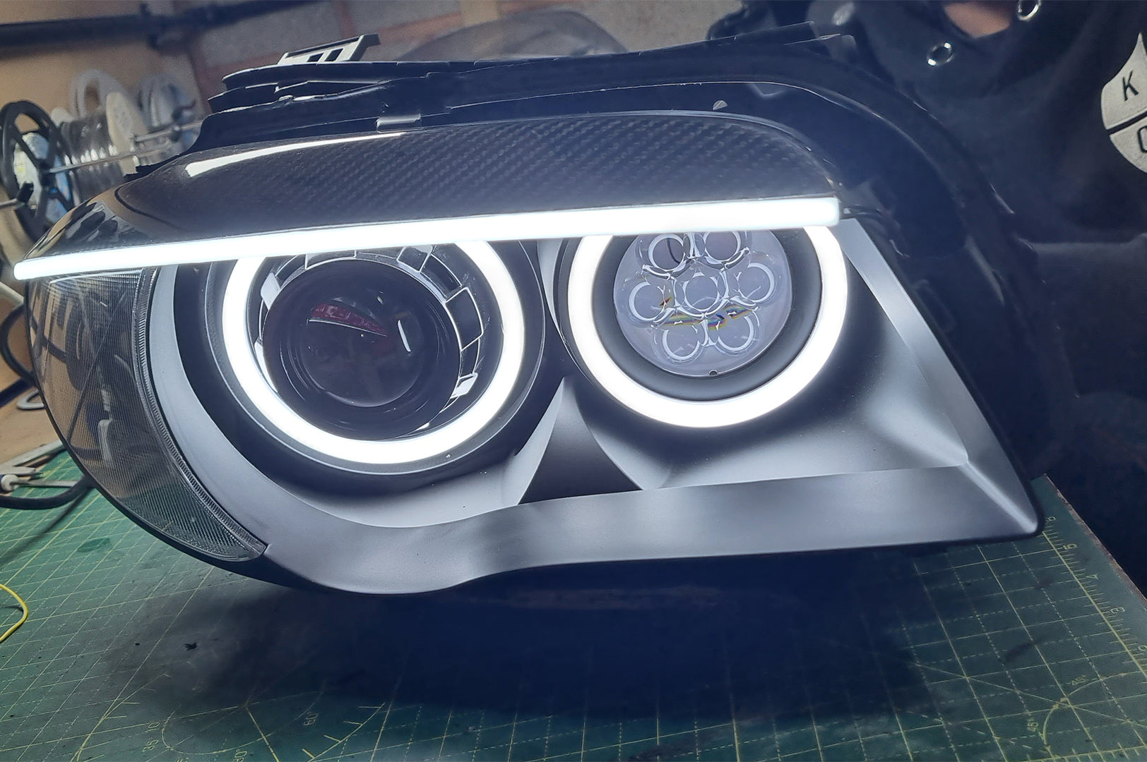 BMW 1 Series E87 & E81 E82 E88 (Pre LCI Halogen) Custom Headlights. Equipped With The Following Options: KYCS Round Angel Eyes (White) | BavGruppe Design Carbon Fibre Eyebrow With LED Strip (White) | Bi-LED Projector | LED High Beam Array