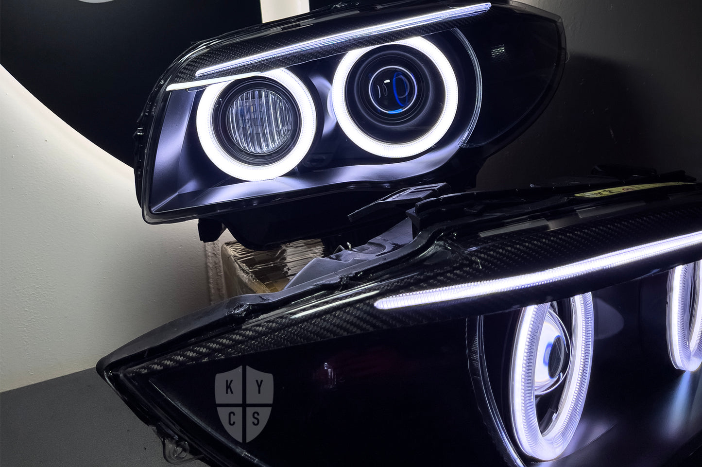 BMW 1 Series E87 & E81 E82 E88 (Pre LCI Xenon/Adaptive Xenon) Custom Headlights. Equipped With The Following Options: BavGruppe Design Round Angel Eyes (White) | BavGruppe Design Carbon Fibre Eyebrow With Optic & LED Strip (White) | G5-BRT Projector & Brackets (Projector Upgrade) | New Headlight Lenses