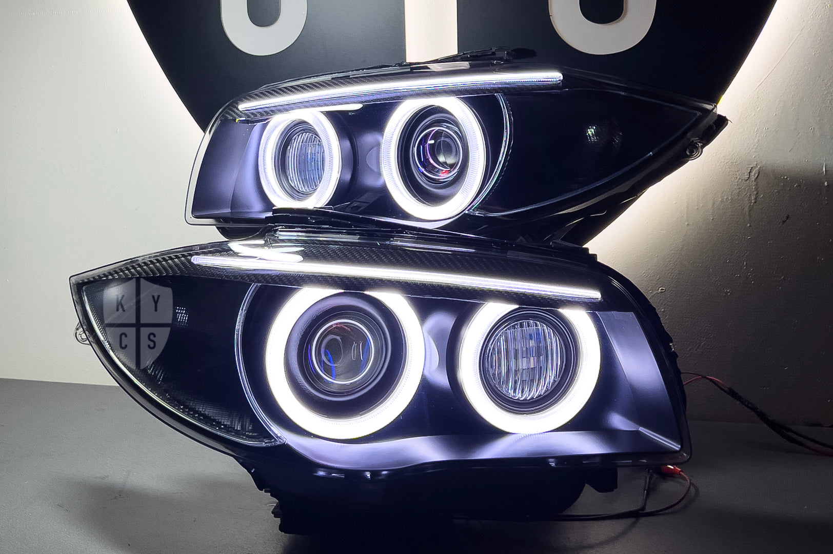 BMW 1 Series E87 & E81 E82 E88 (Pre LCI Xenon/Adaptive Xenon) Custom Headlights. Equipped With The Following Options: BavGruppe Design Round Angel Eyes (White) | BavGruppe Design Carbon Fibre Eyebrow With Optic & LED Strip (White) | G5-BRT Projector & Brackets (Projector Upgrade) | New Headlight Lenses