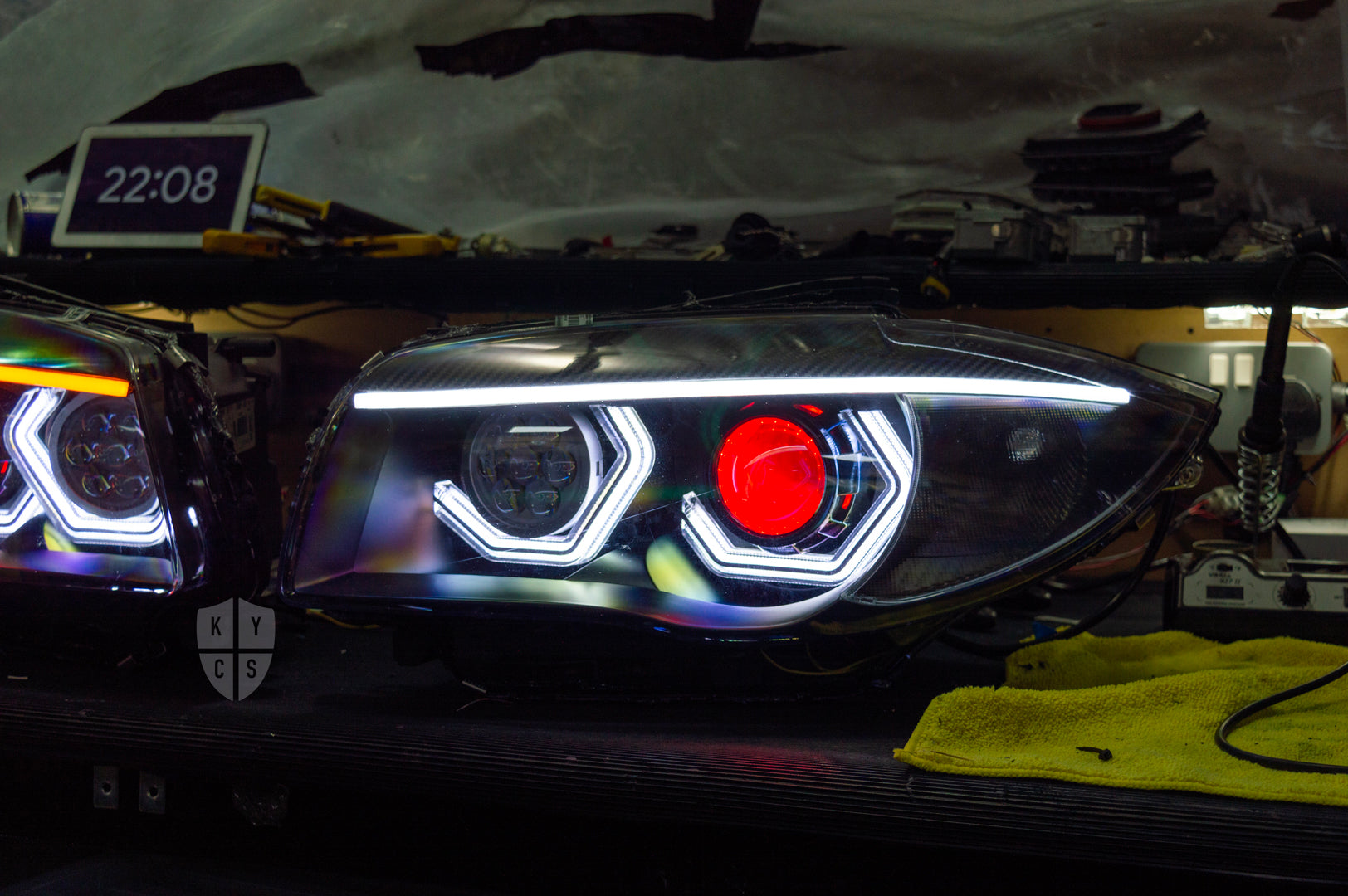 BMW 1 Series E87 & E81 E82 E88 (Pre LCI Halogen) Custom Headlights. Equipped With The Following Options: BavGruppe Design Vision Angel Eyes (White) | BavGruppe Design Carbon Fibre Eyebrow With LED Strip (White) | Bi-LED Projector | LED High Beam Array | Red Demon Eye | New Headlight Lenses