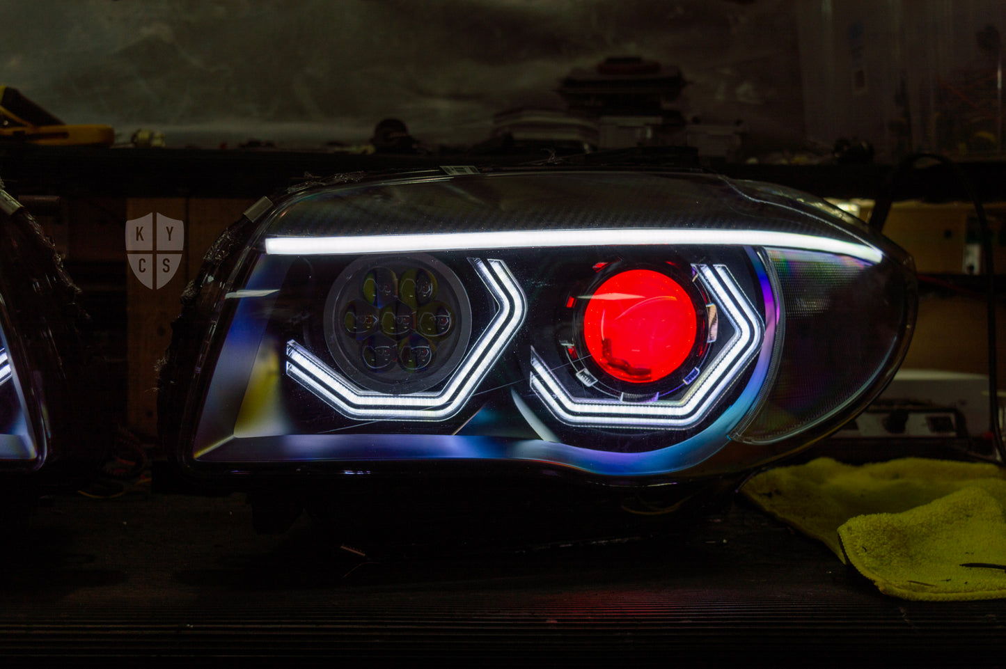 BMW 1 Series E87 & E81 E82 E88 (Pre LCI Halogen) Custom Headlights. Equipped With The Following Options: BavGruppe Design Vision Angel Eyes (White) | BavGruppe Design Carbon Fibre Eyebrow With LED Strip (White) | Bi-LED Projector | LED High Beam Array | Red Demon Eye | New Headlight Lenses