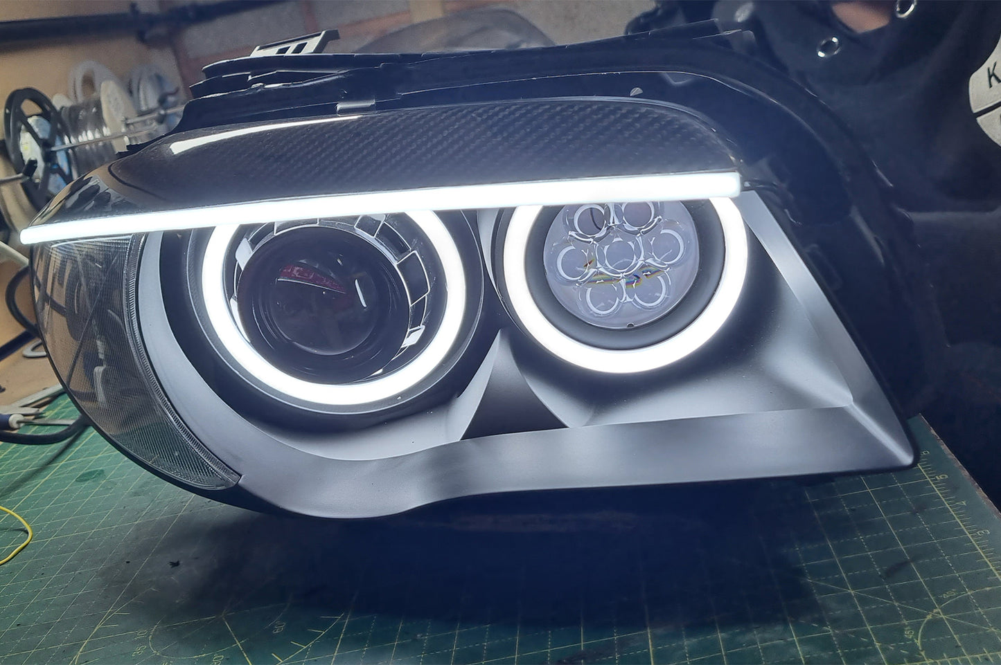 BMW 1 Series E87 & E81 E82 E88 (Pre LCI Halogen) Custom Headlights. Equipped With The Following Options: KYCS Round Angel Eyes (White) | BavGruppe Design Carbon Fibre Eyebrow With LED Strip (White) | Bi-LED Projector | LED High Beam Array